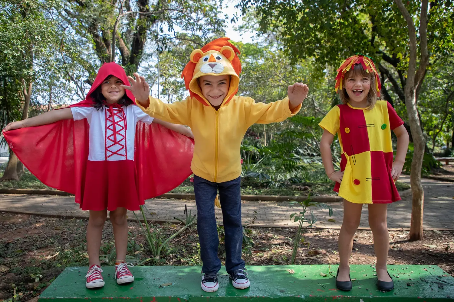 Três crianças fantasiadas no parque - Just Real Moms