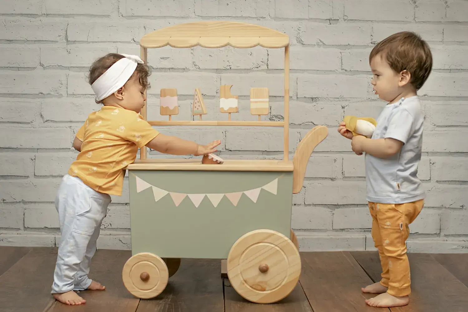 Crianças brincando em carrinho de sorvete de madeira